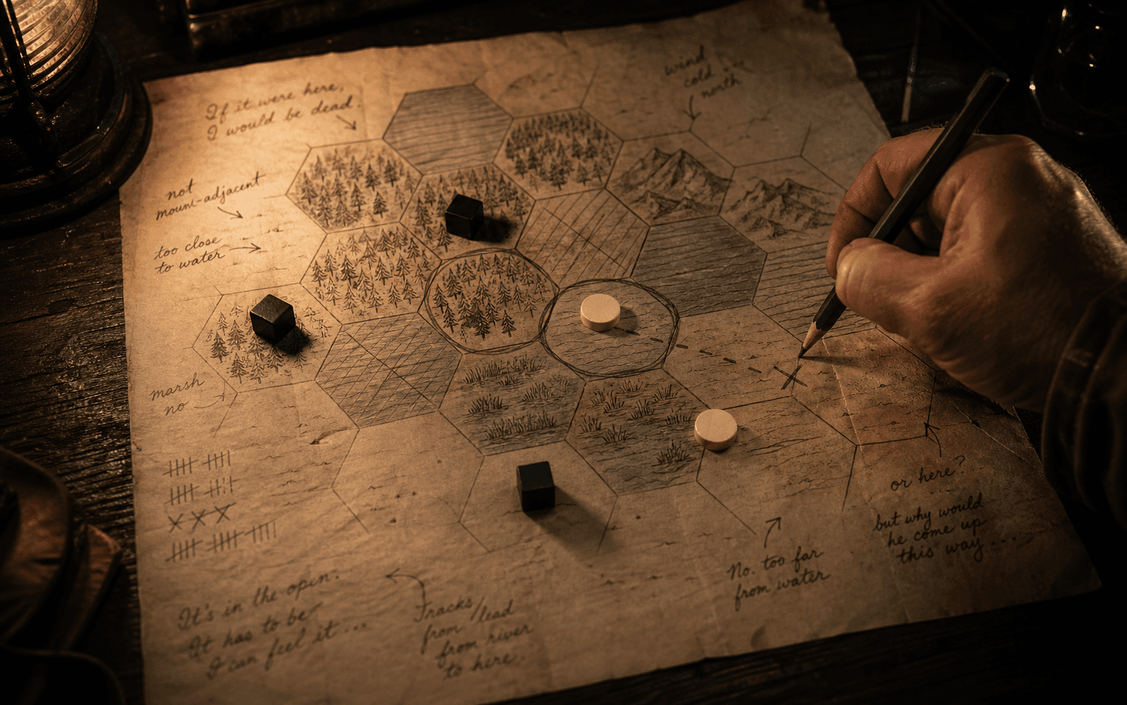 Overhead view of a hand-drawn hexagonal topographic map covered in pencil deduction work — X marks through eliminated hexes, a graphite circle around the surviving cluster, three black cubes and two ivory discs placed on hexes, and cursive marginalia in the parchment's edges; a hand at the right holds a graphite pencil mid-stroke.